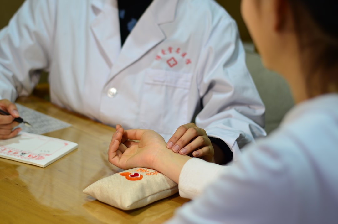 TCM physician conducting pulse diagnosis during consultation